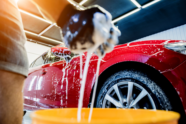 a man using a bucket for a carwash