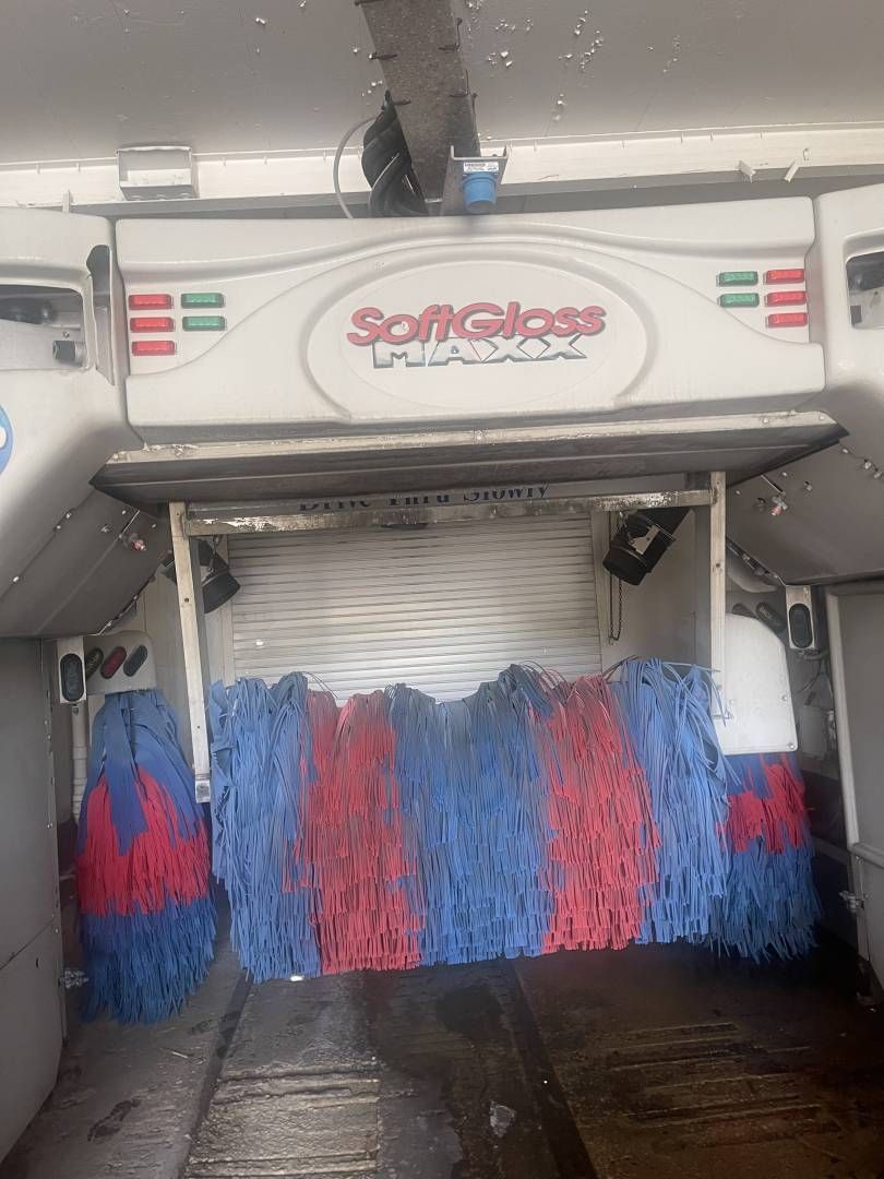 A car is being washed in a softglass car wash