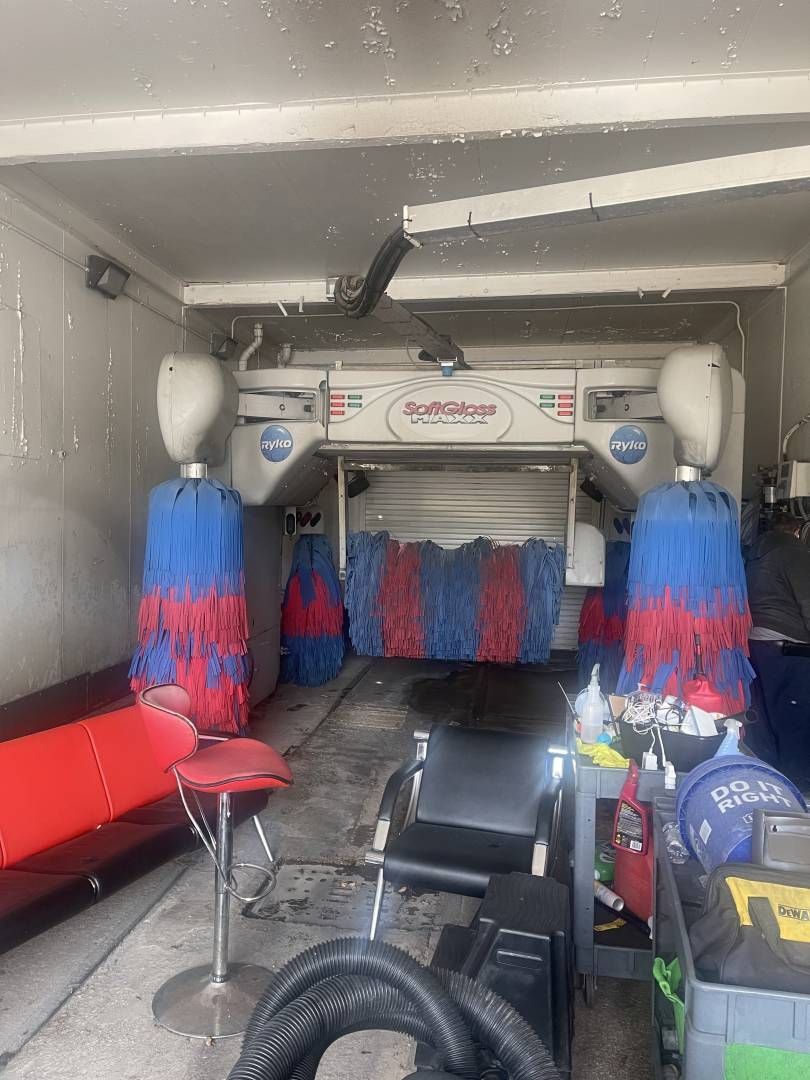 A car wash in a garage with a red and blue brush.