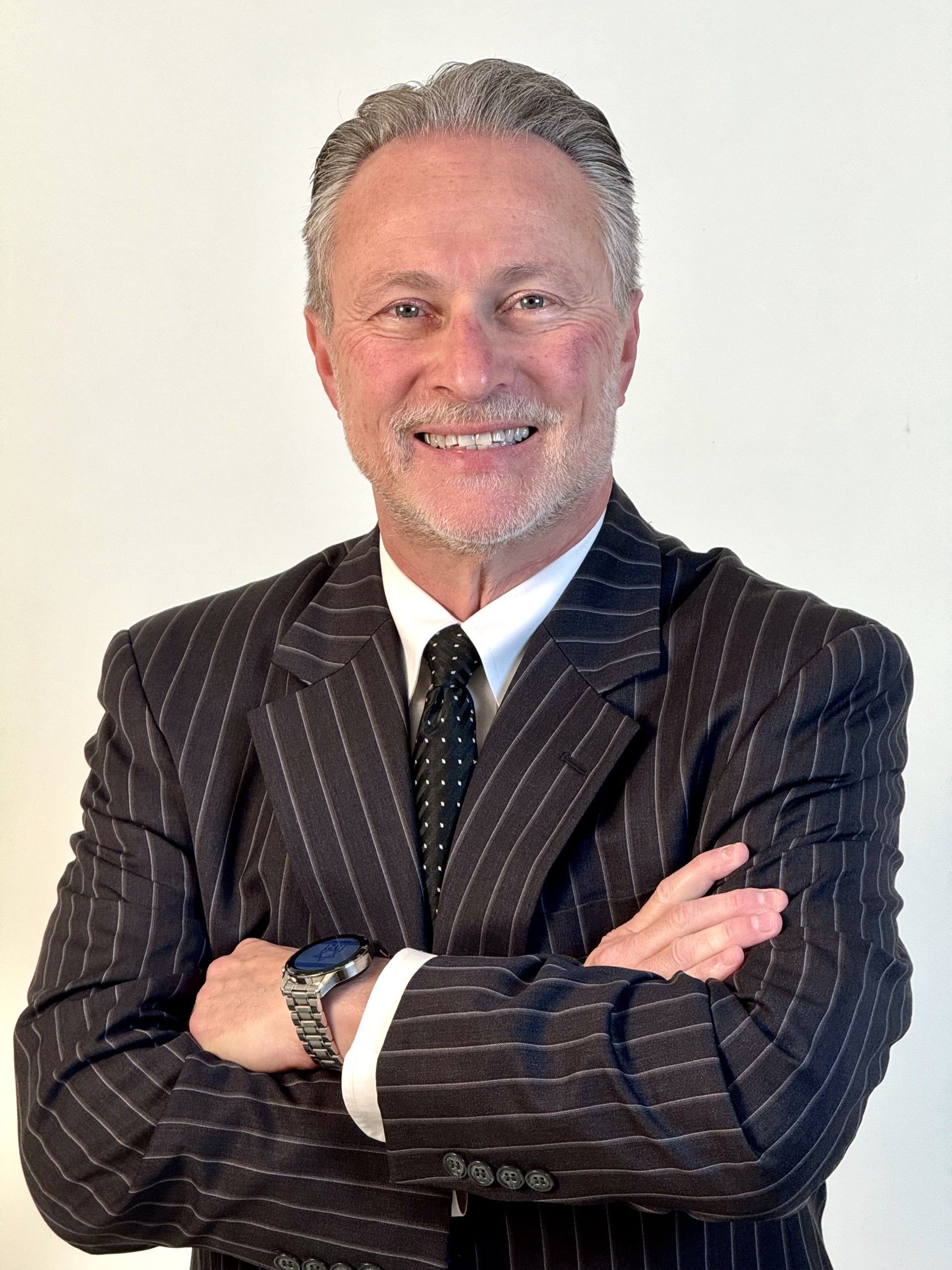 A man in a suit and tie with his arms crossed