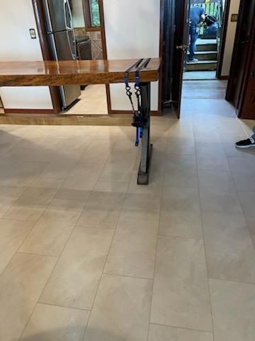 A kitchen with a wooden table and a dog leash on the floor.