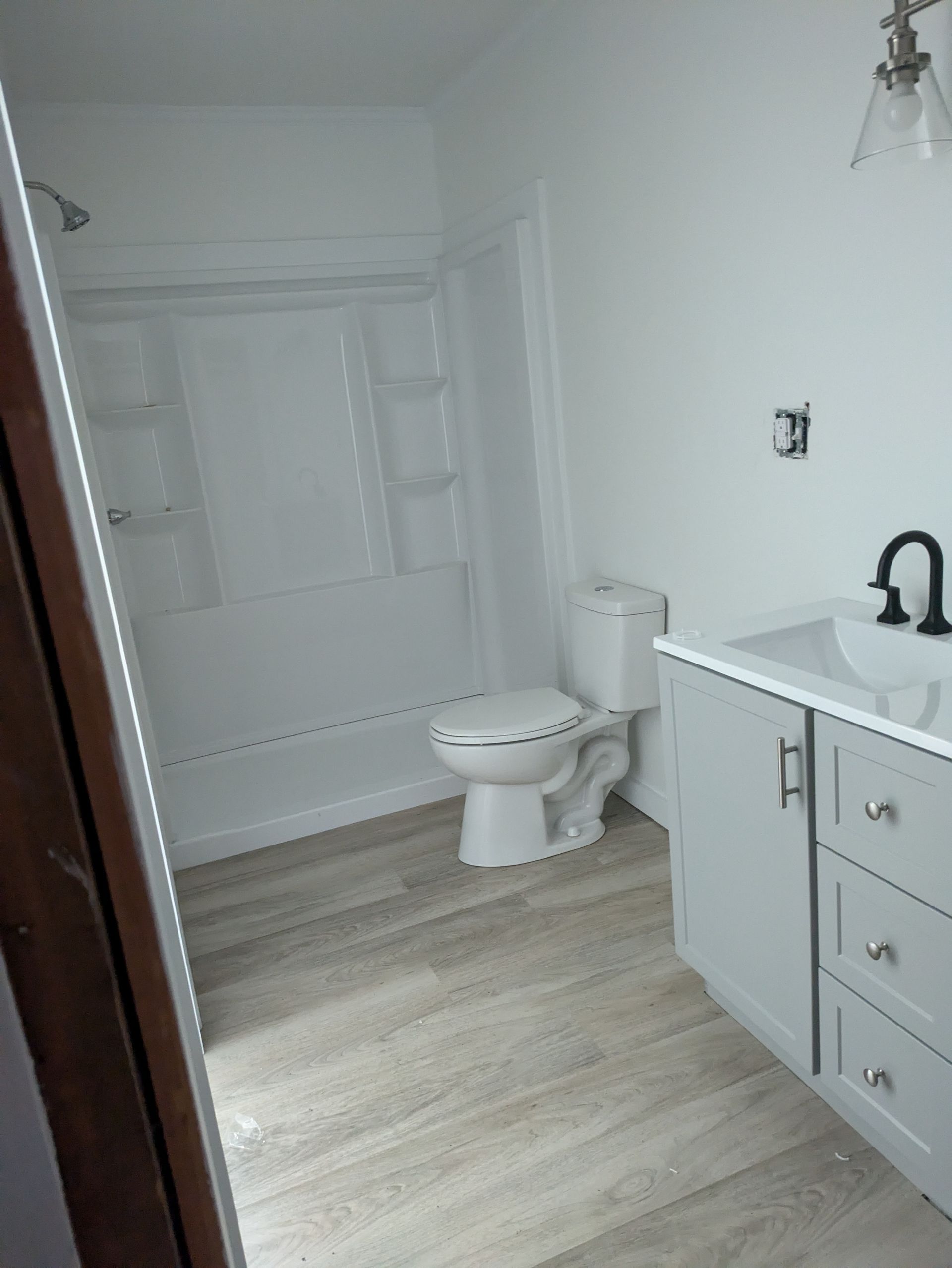 A bathroom with a toilet , sink , and shower.