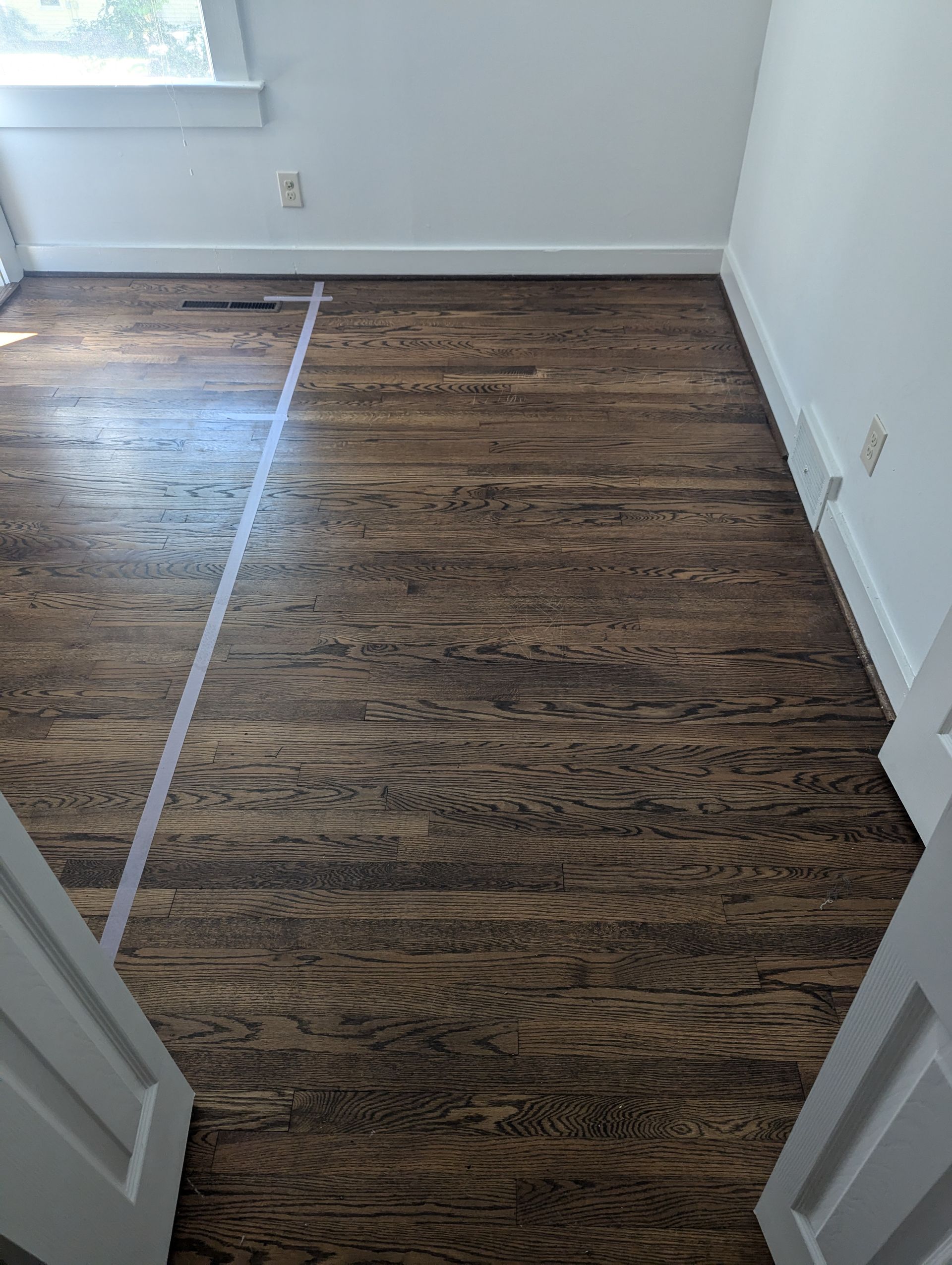 A room with hardwood floors and white walls.