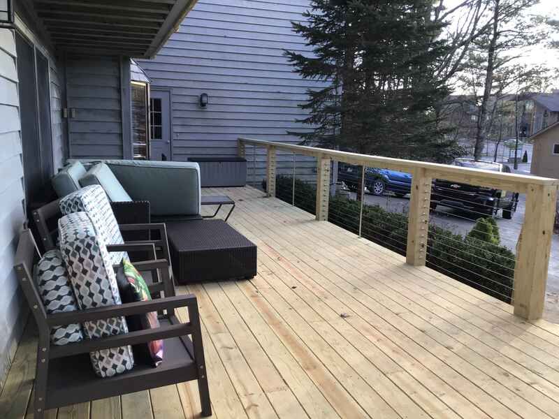 A wooden deck with a couch and chairs on it
