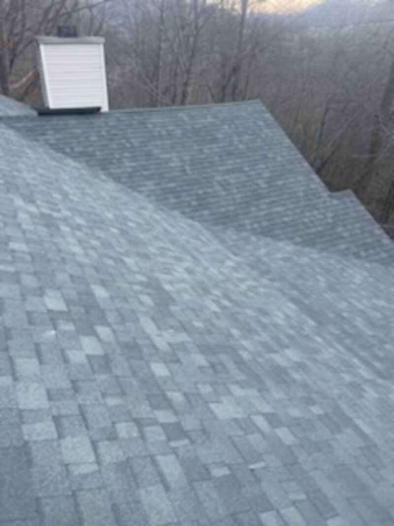 A close up of a roof with a chimney on top of it.