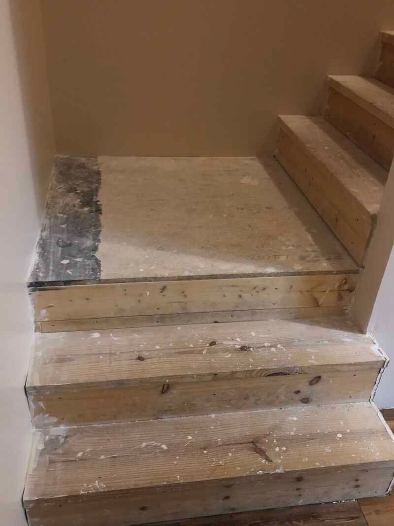 A set of wooden stairs being built in a room.