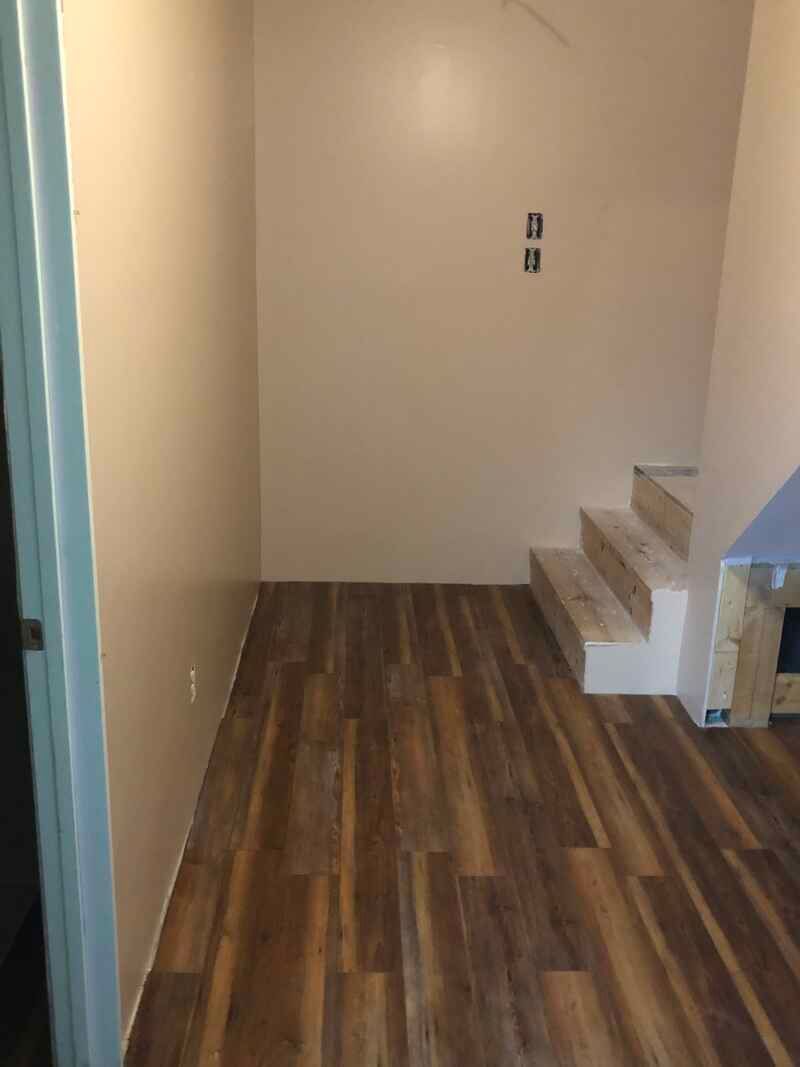 A room with wooden floors and stairs in it.