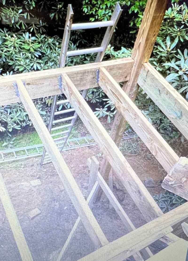 A wooden structure is being built with a ladder in the background.