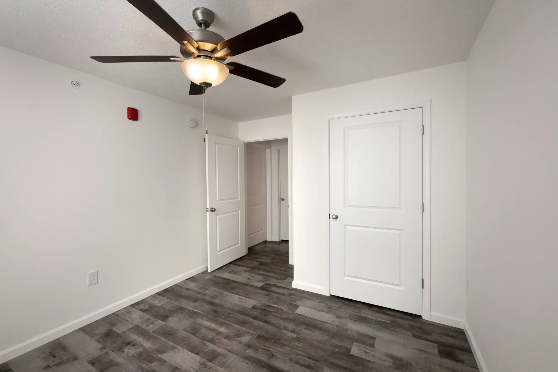 Inviting bedroom space with updated vinyl plank flooring, ceiling fan, and abundant natural light.