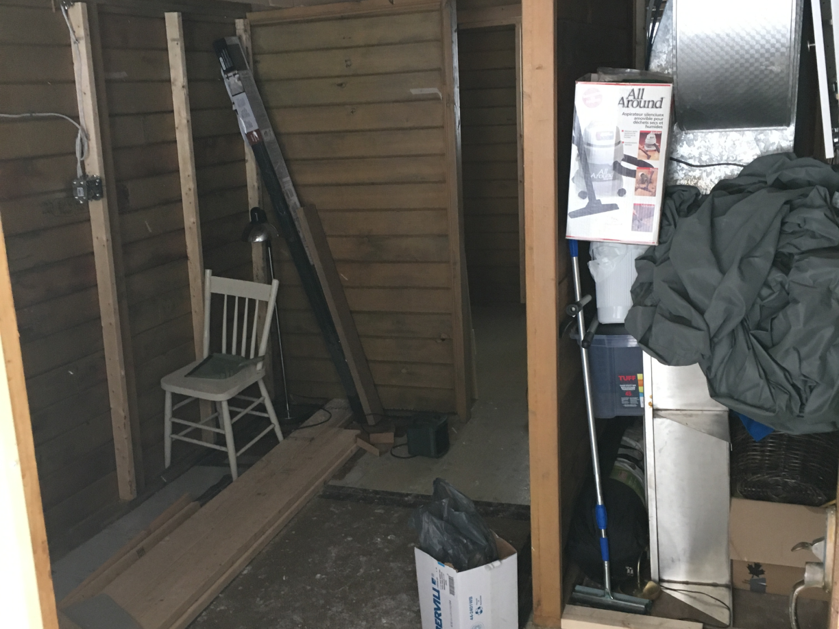 A white chair is sitting in a room with a box on the floor.