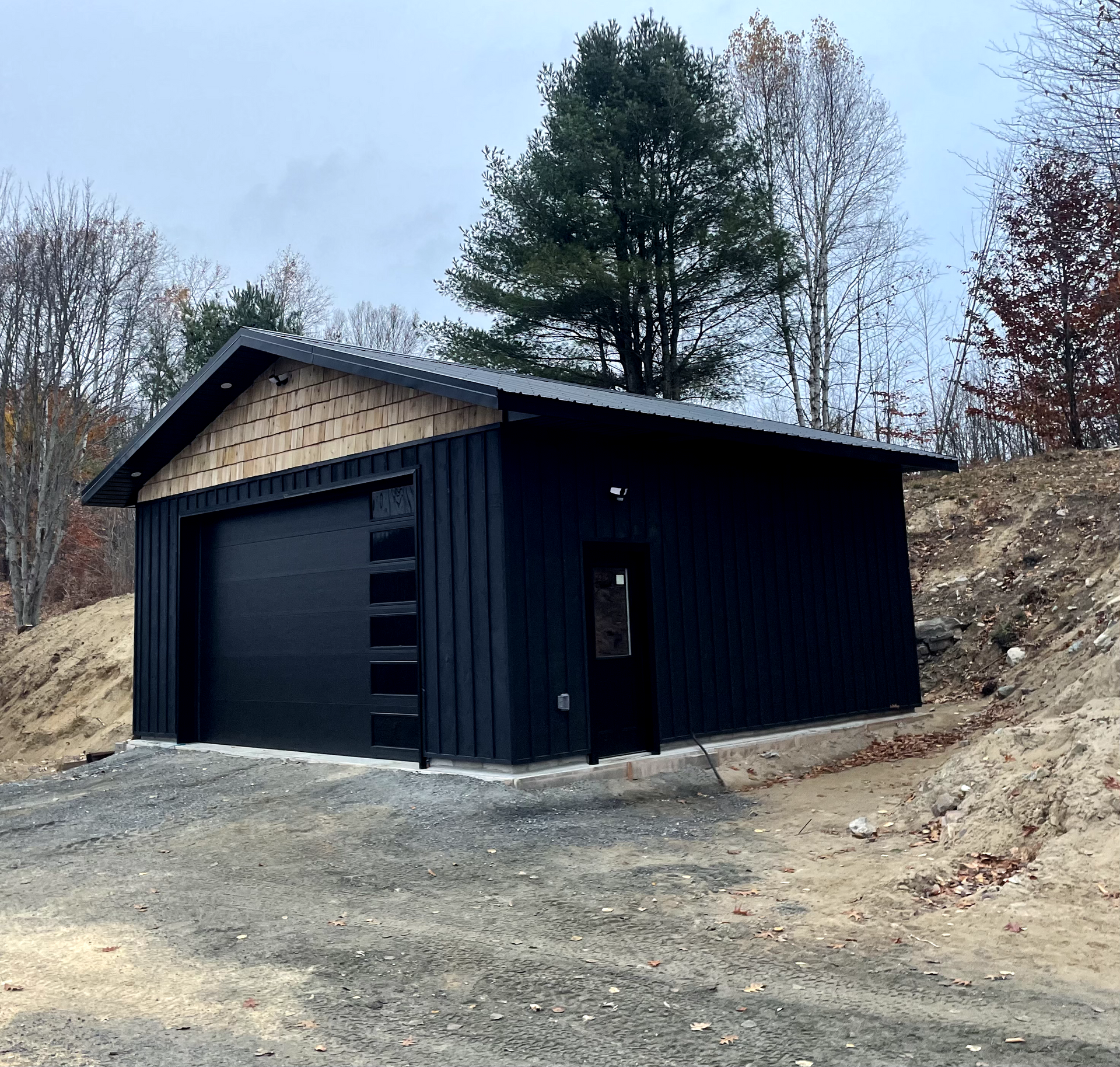 A black garage with a roof and a door