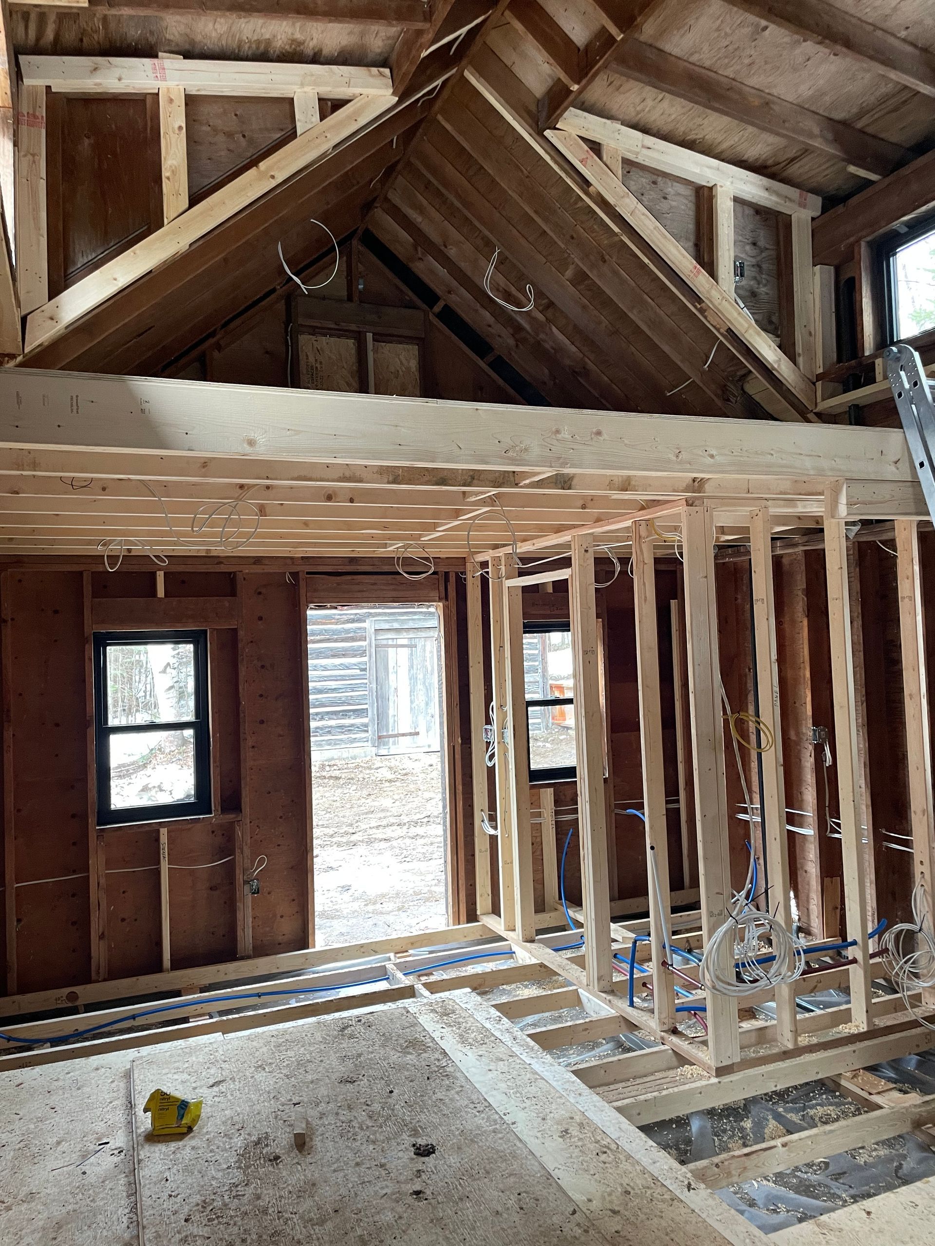 A house is being built with wooden beams and a vaulted ceiling.