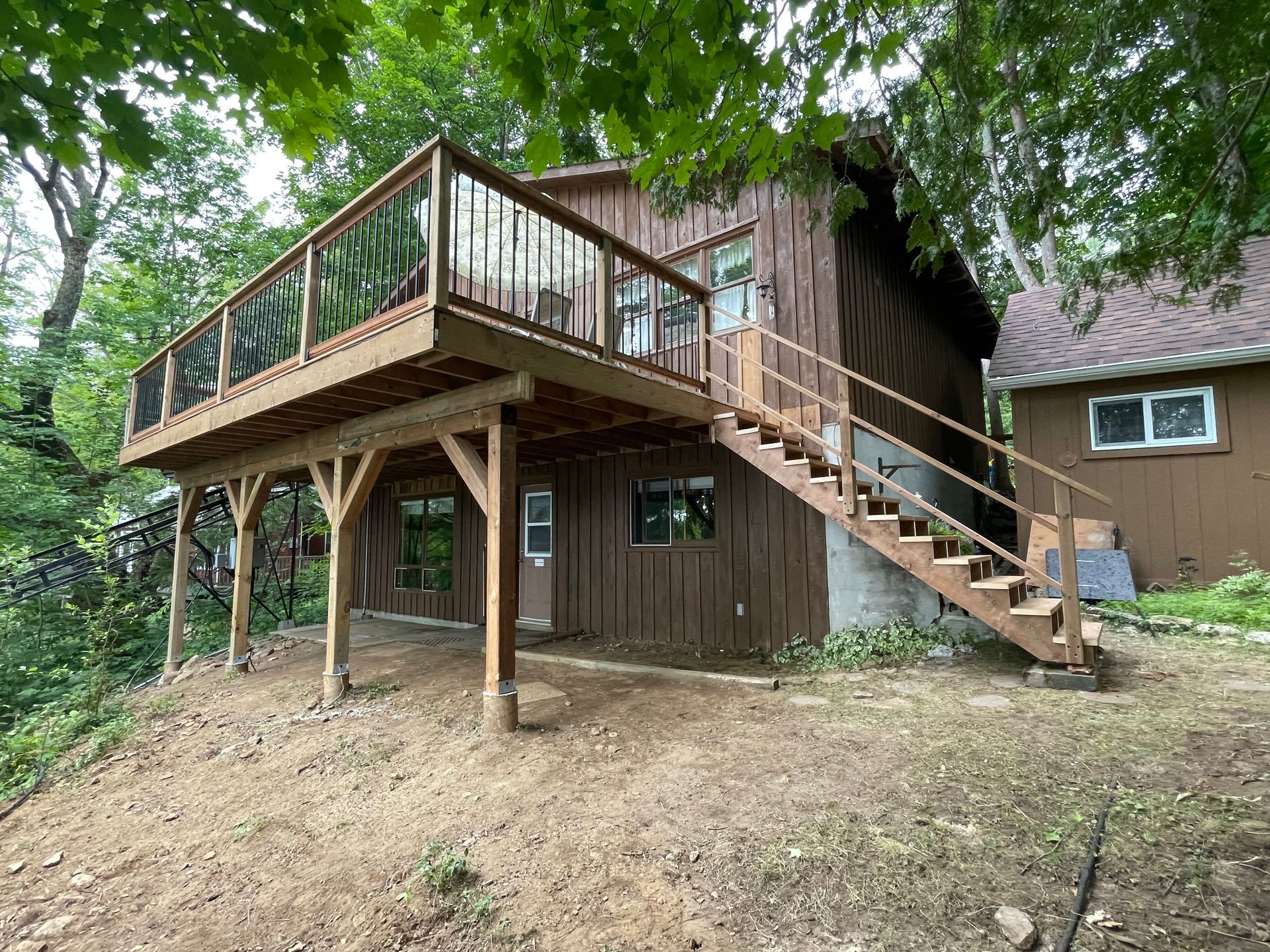 A wooden house with a large deck and stairs.