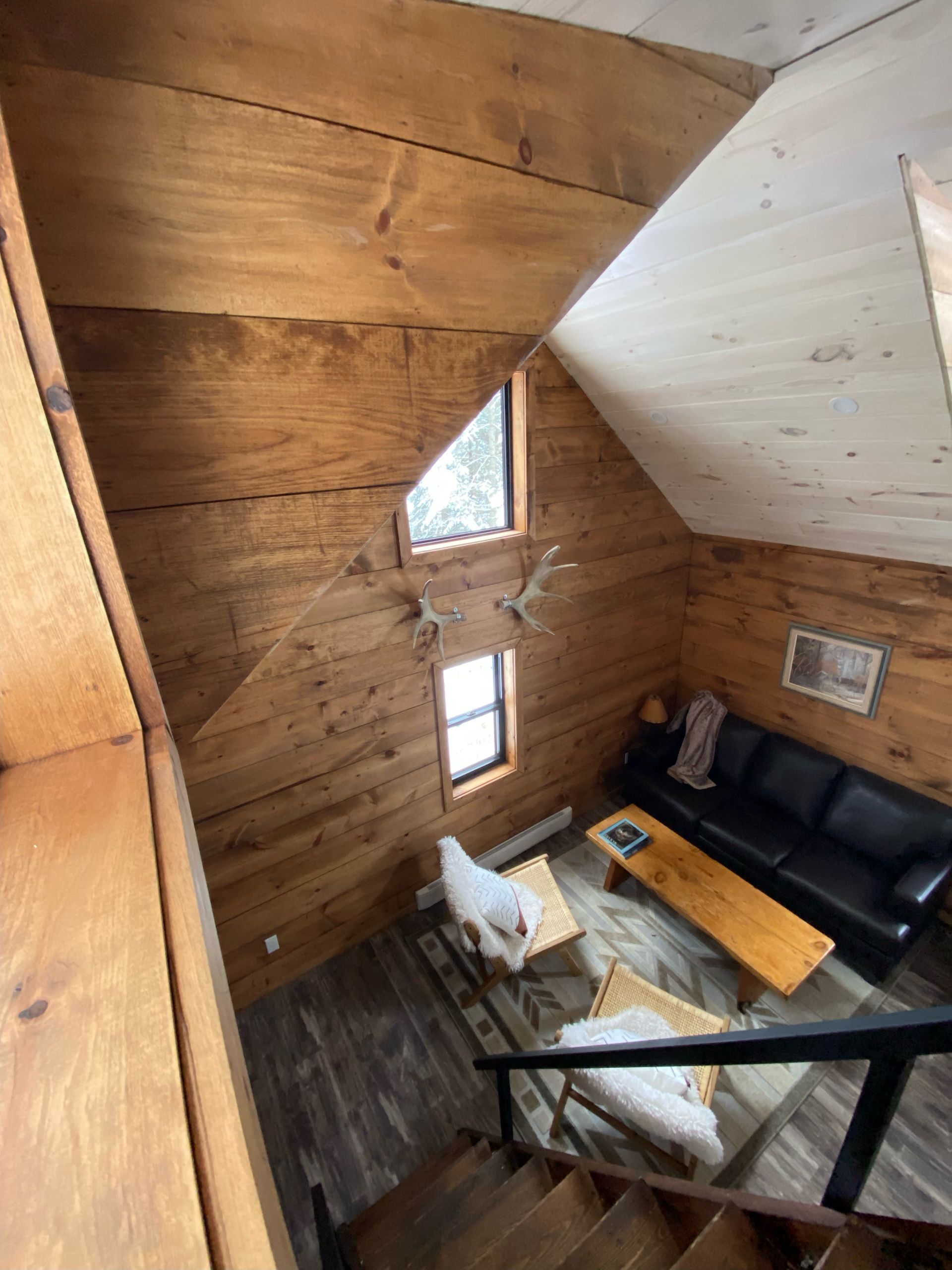 An aerial view of a living room with stairs leading up to it.