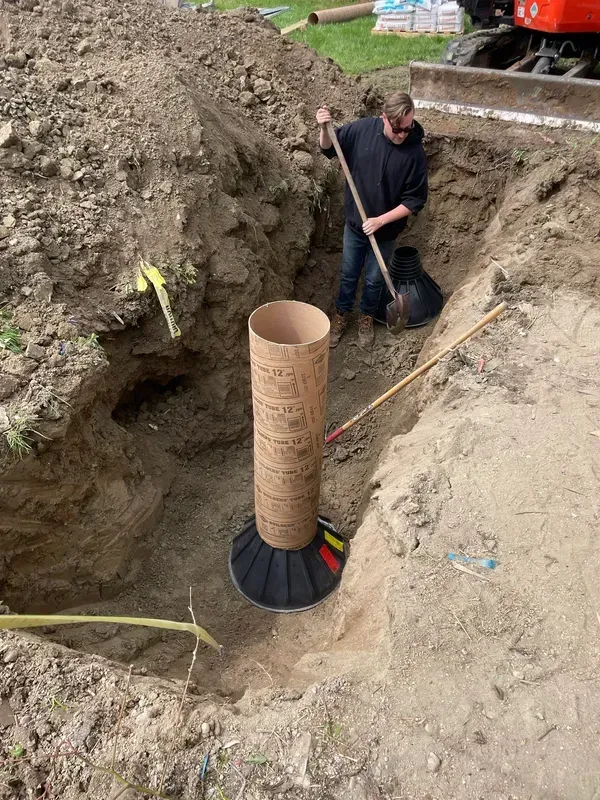 A man is digging a hole in the ground with a shovel.