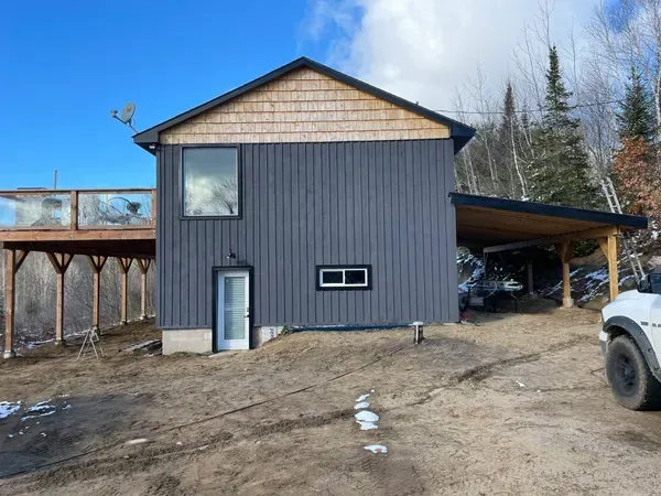 A large house with a carport and a car parked in front of it.