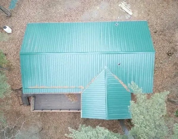 An aerial view of a green roof of a house in the woods.