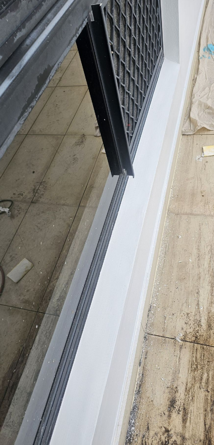 Black metal security grille set into a gray concrete ledge — Prestige Painting NT in Zuccoli, NT