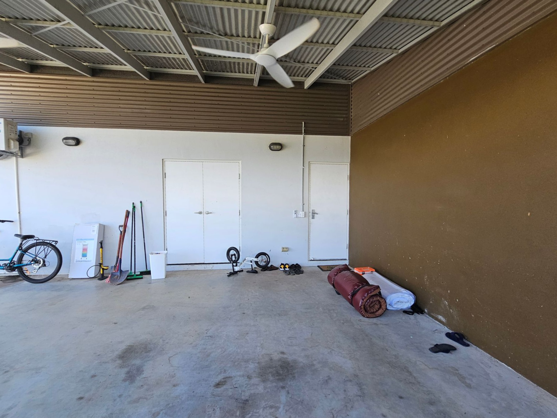 Covered outdoor area with white and brown walls, ceiling fan, and various objects — Prestige Painting NT in Zuccoli, NT