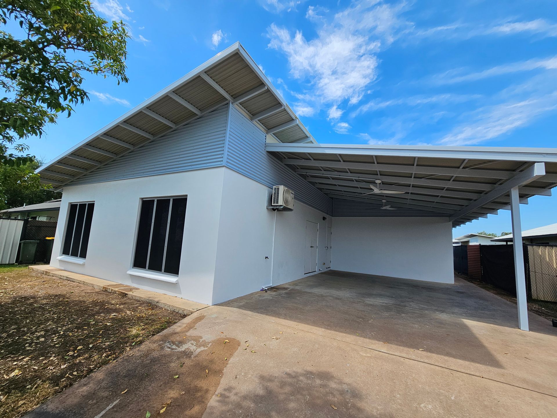 A single-story, white house with a carport under a bright blue sky — Prestige Painting NT in Zuccoli, NT