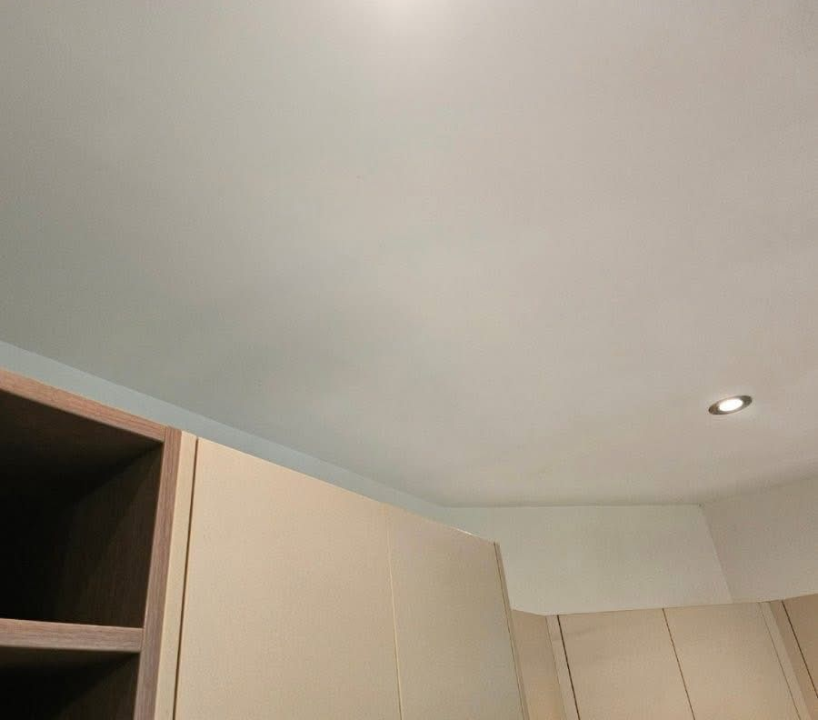 Light-coloured kitchen cabinets with a white ceiling and recessed lighting — Prestige Painting NT in Zuccoli, NT
