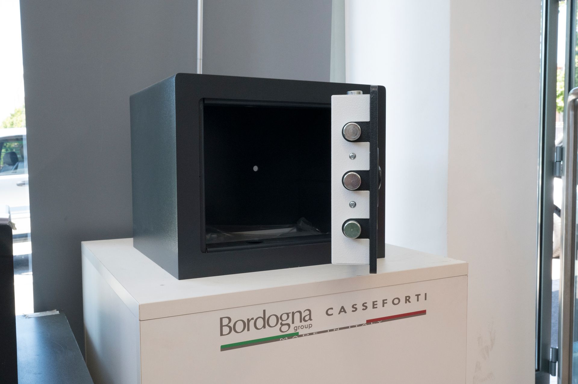 Forno da appoggio nero su piedistallo bianco nella vetrina di uno showroom.