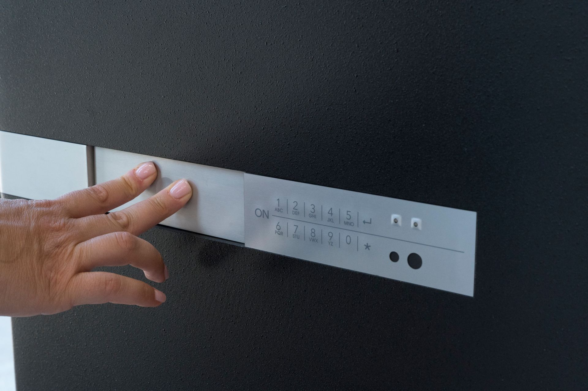 Misurazione manuale di un pannello metallico rettangolare bianco contro una superficie scura