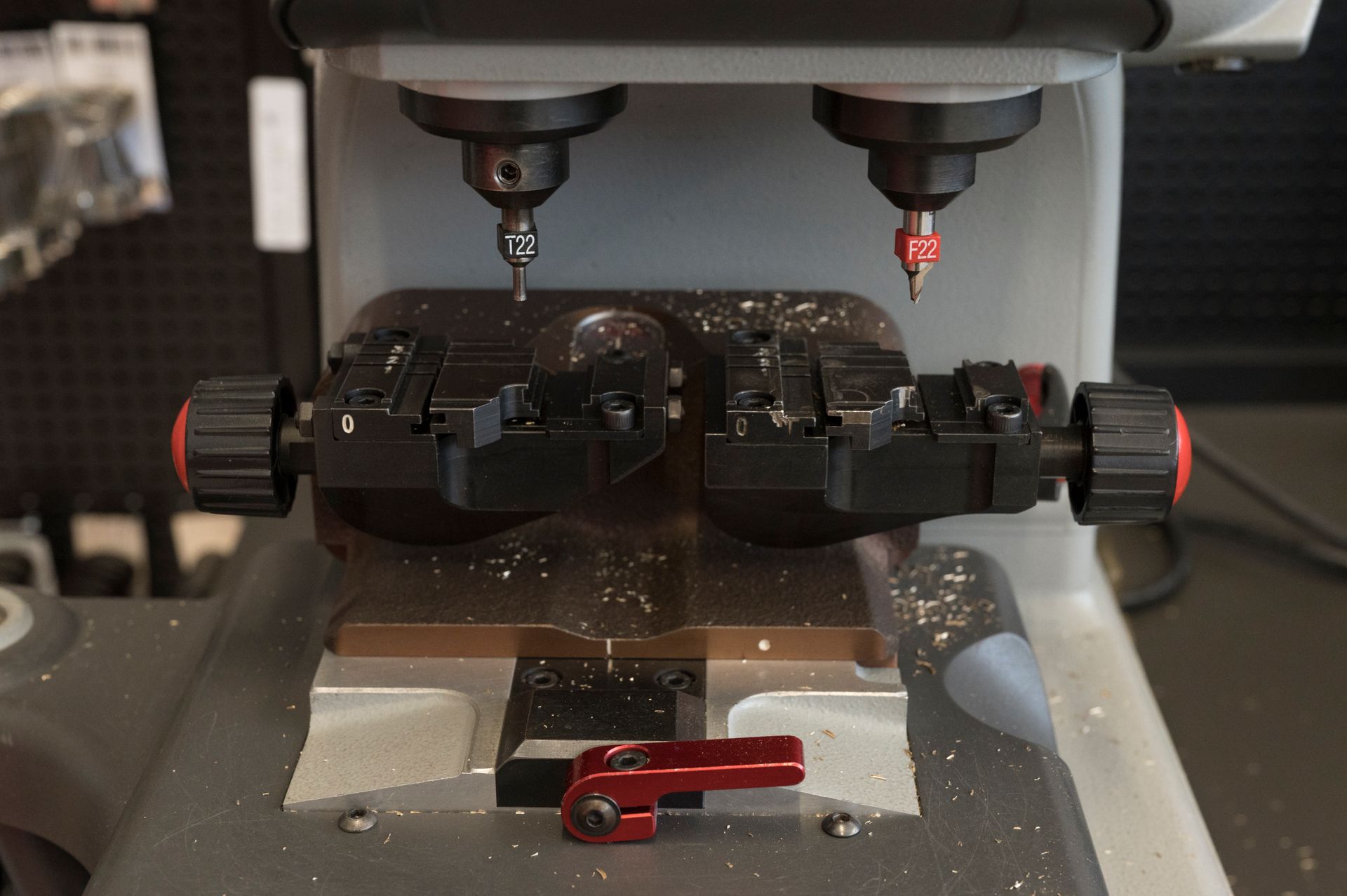 Macchina CNC per la lavorazione dei metalli che incide un pezzo nero con morsetti rossi in un'officina