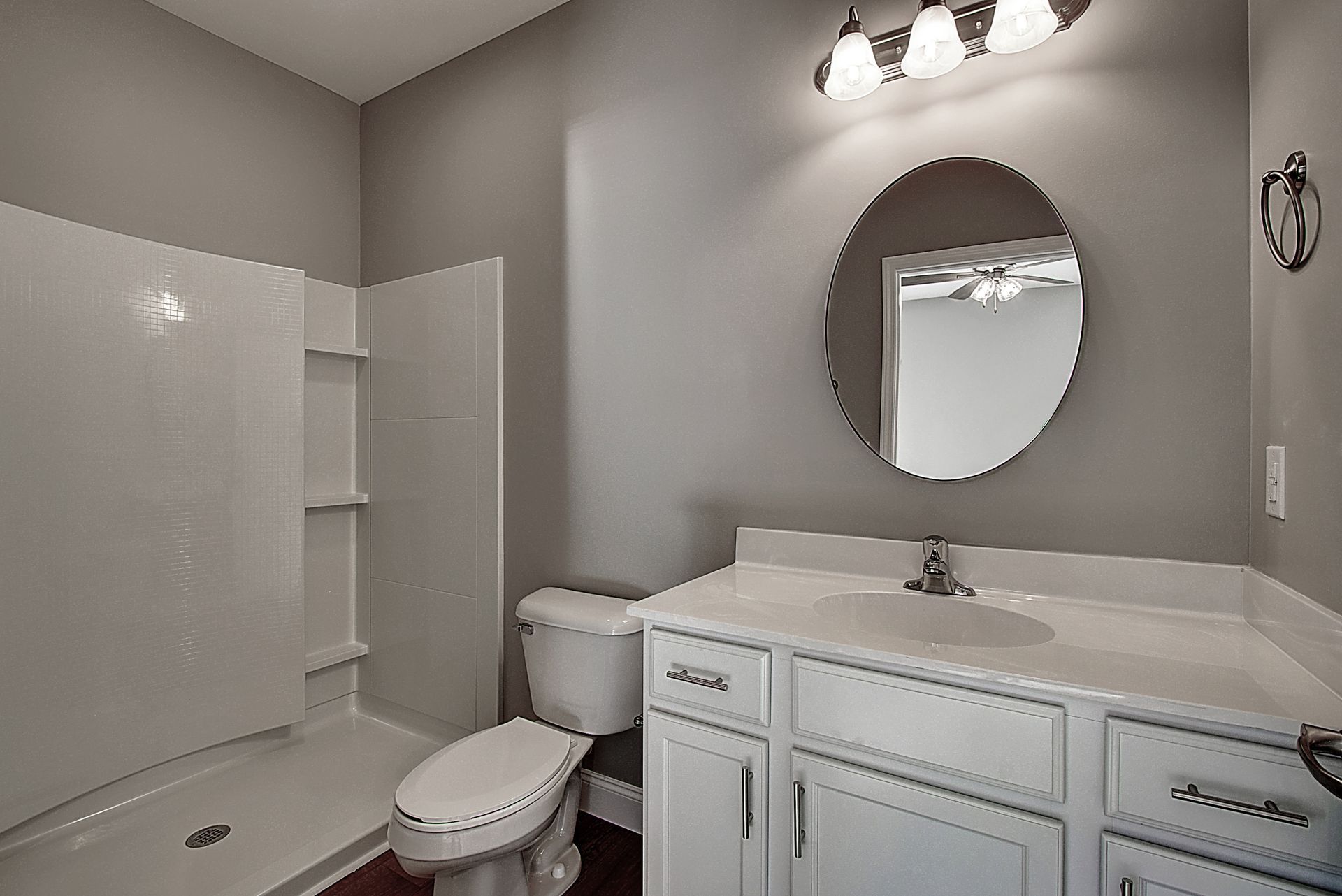 A bathroom with a toilet , sink , and mirror.
