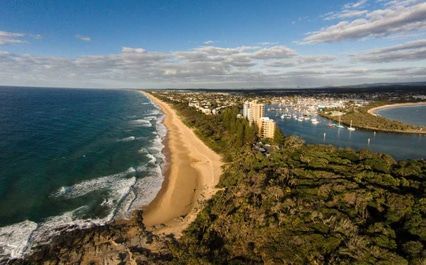 An Aerial View Of A Beach Surrounded By Trees And A Body Of Water — Brisbane Moving & Storage In Sunshine Coast, QLD