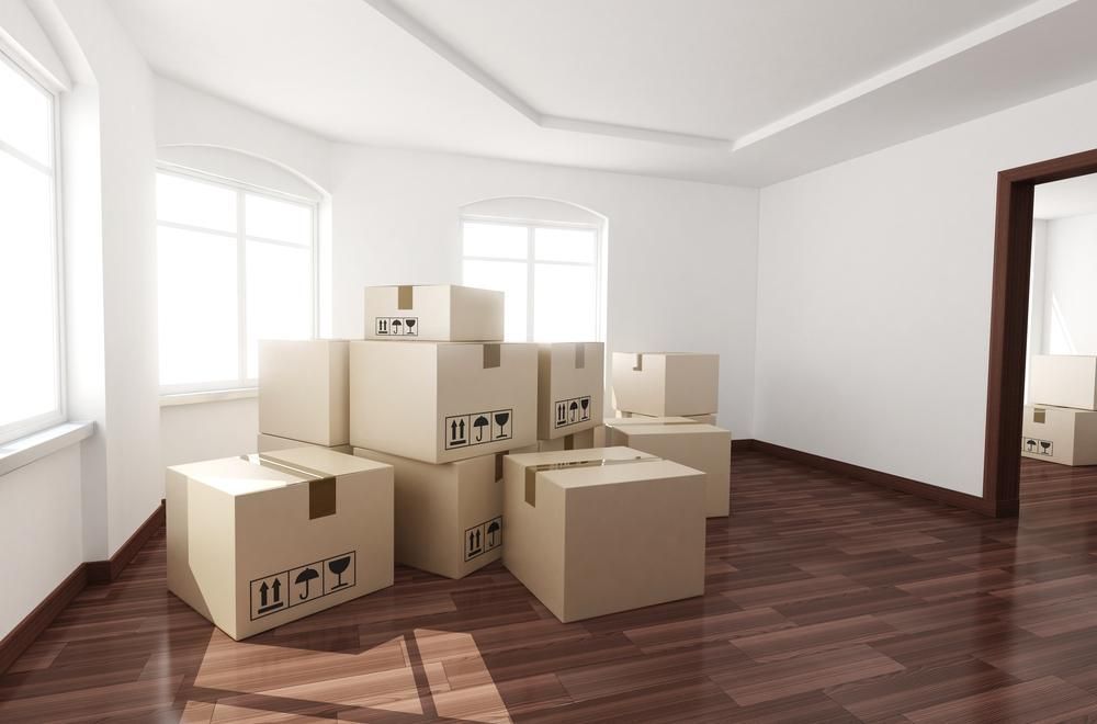A Bunch Of Cardboard Boxes Are Stacked On Top Of Each Other In An Empty Room — Brisbane Moving & Storage In Acacia Ridge, QLD