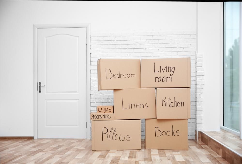 A Bunch Of Cardboard Boxes Are Stacked On Top Of Each Other In An Empty Room — Brisbane Moving & Storage In Acacia Ridge, QLD