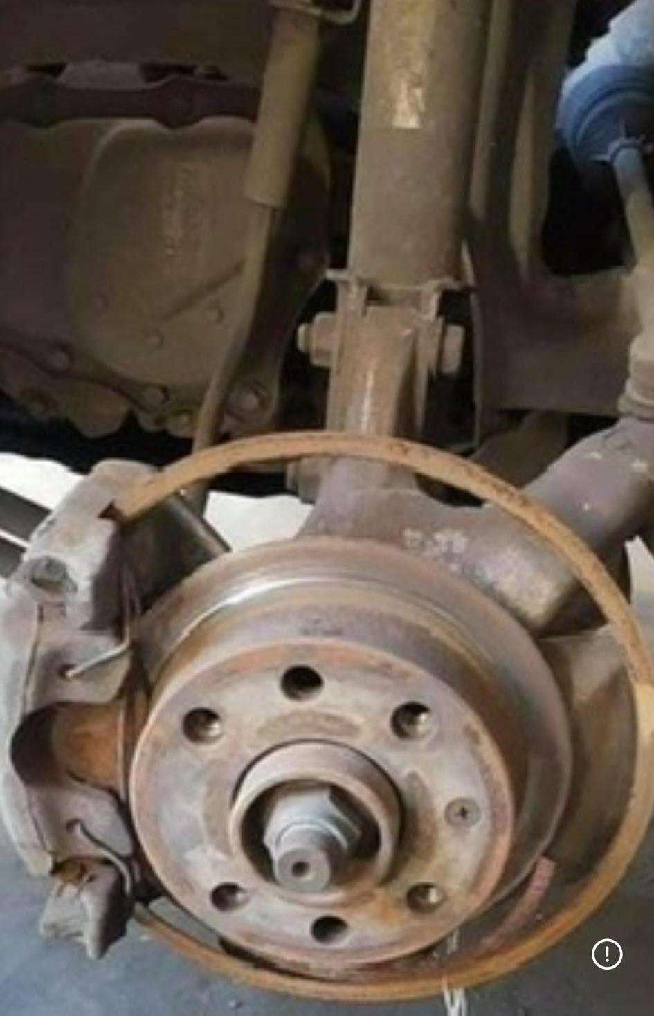 Car wheel hub and brake rotor with exposed suspension parts underneath a vehicle