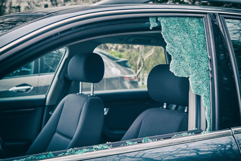A Man is Installing a Windshield on a Car — Keppel Coast Windscreens in Emu Park, QLD