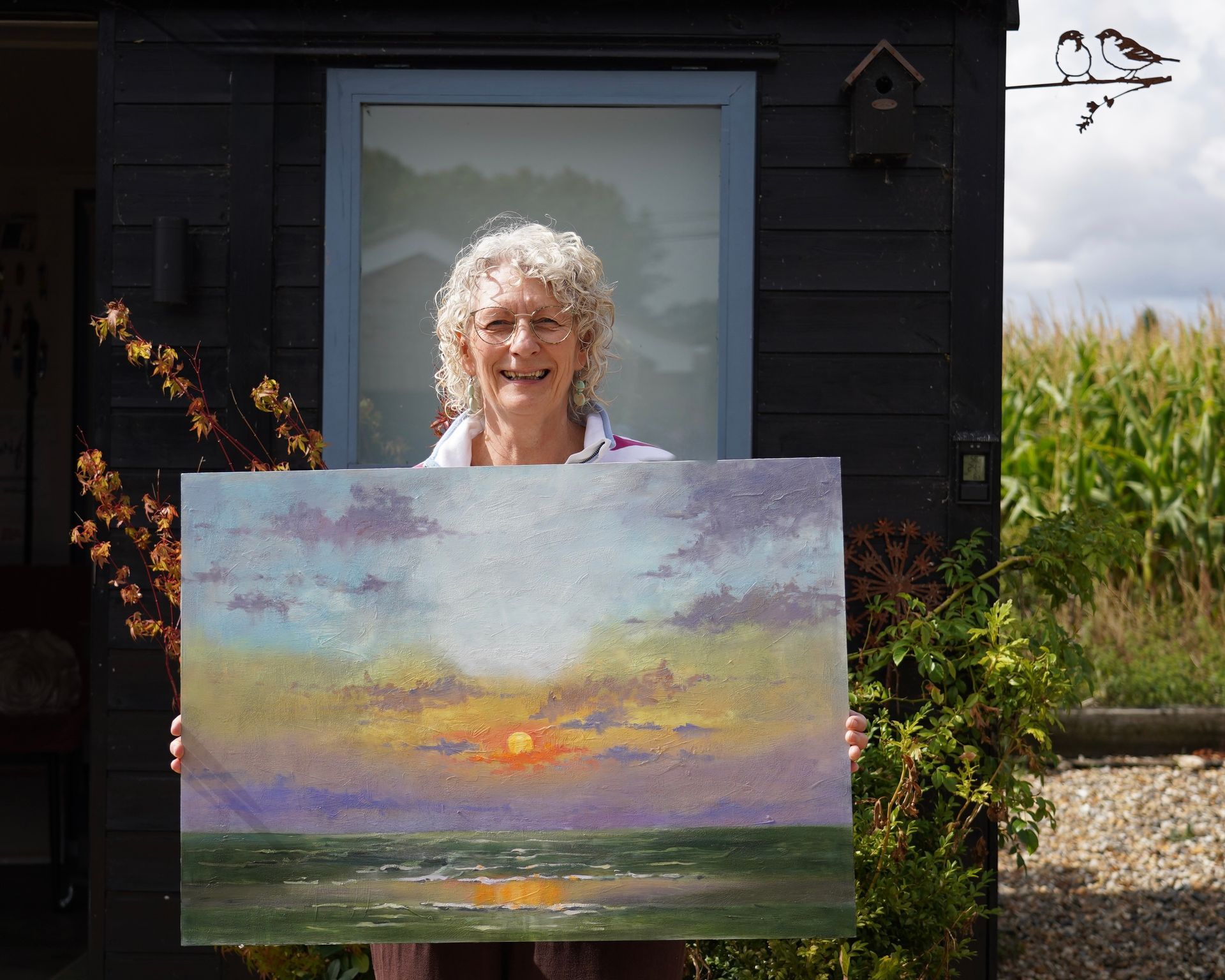 Jackie Smerdon Art tutor holding one of her oil paintings.