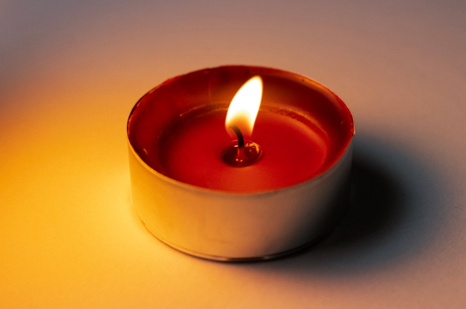 Lit memorial candle representing lasting remembrance in Mesa, AZ.