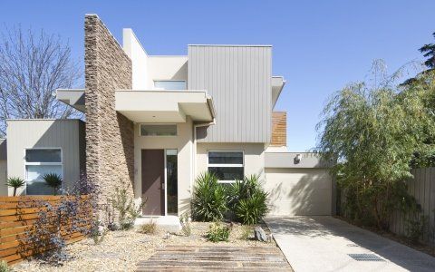 Moderna casa a due piani con serramenti marroni e bianchi