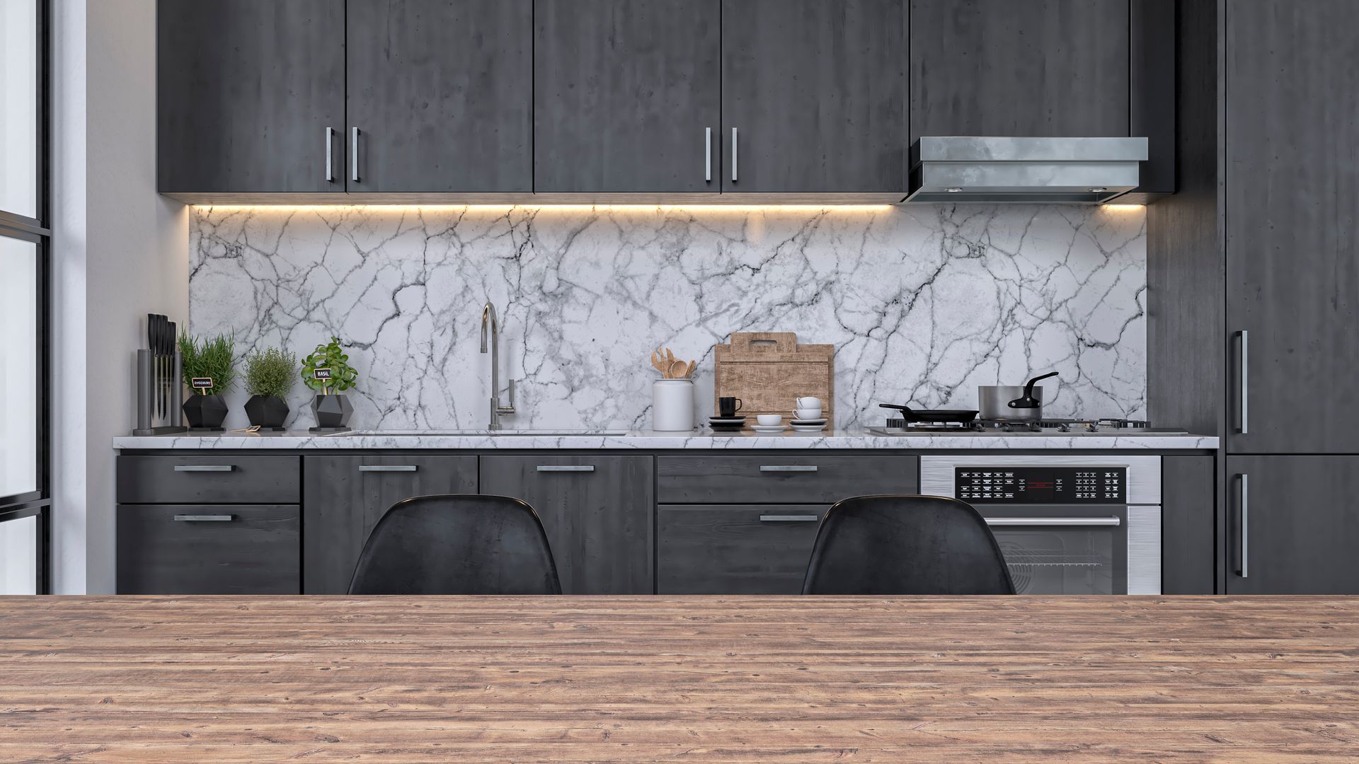 Cucina moderna con mobili grigio scuro, paraschizzi in marmo, elettrodomestici in acciaio inossidabile e tavolo in legno.