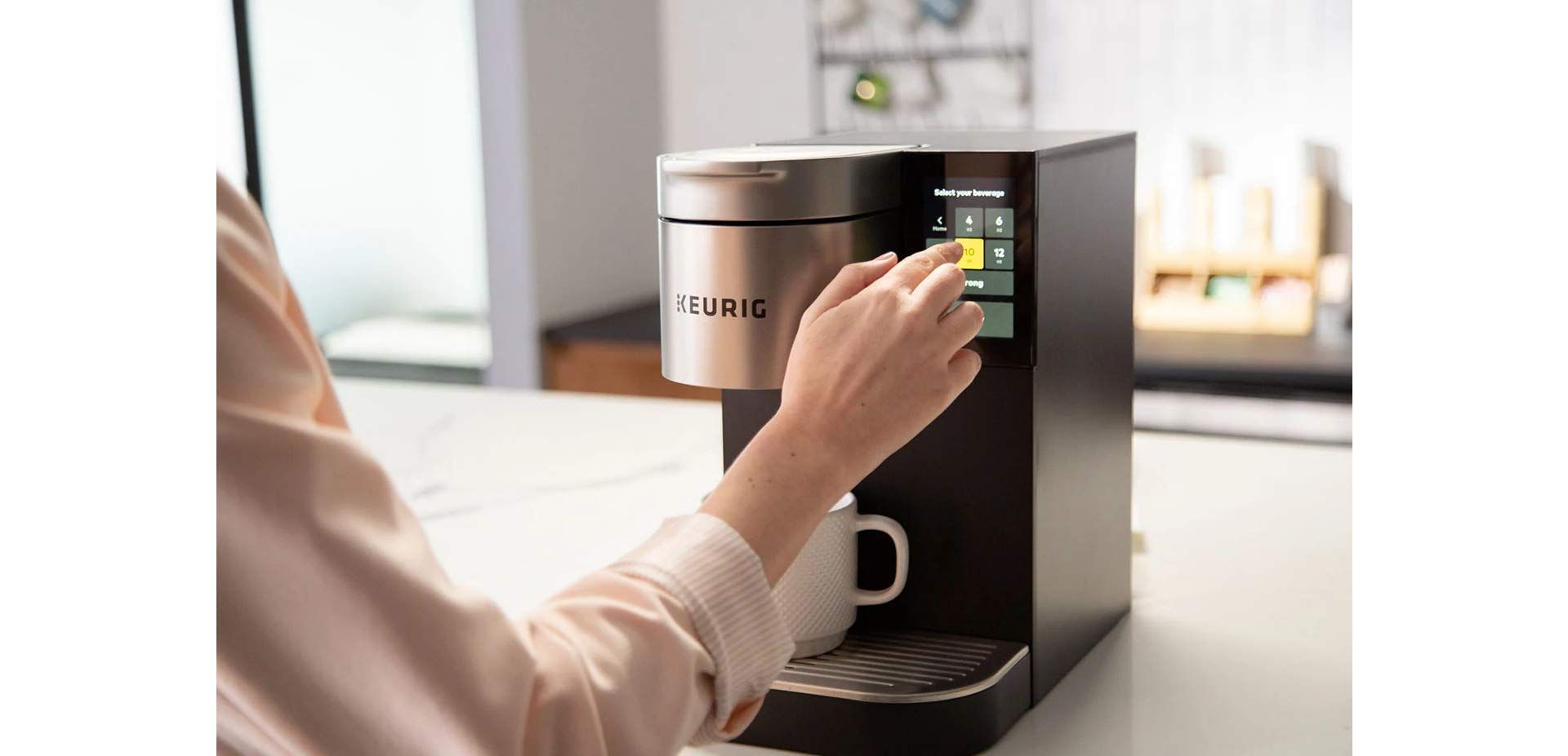 A person is pressing a button on a coffee maker.