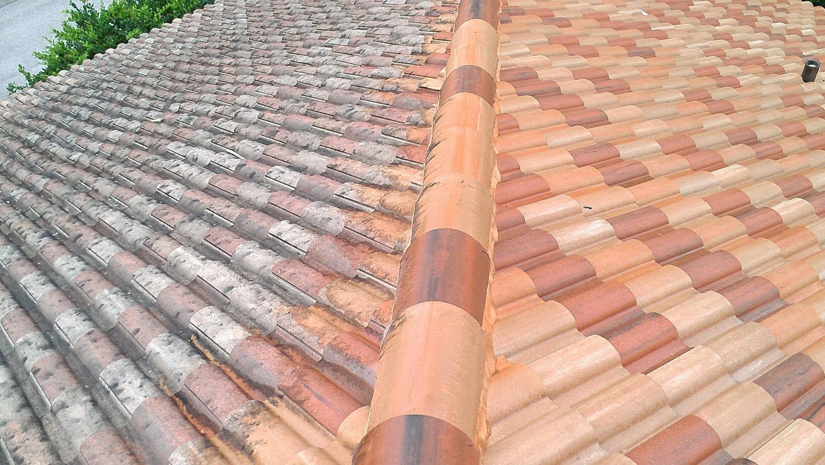 Two sloped clay-tile roof sections meeting at a central ridge under a cloudy sky