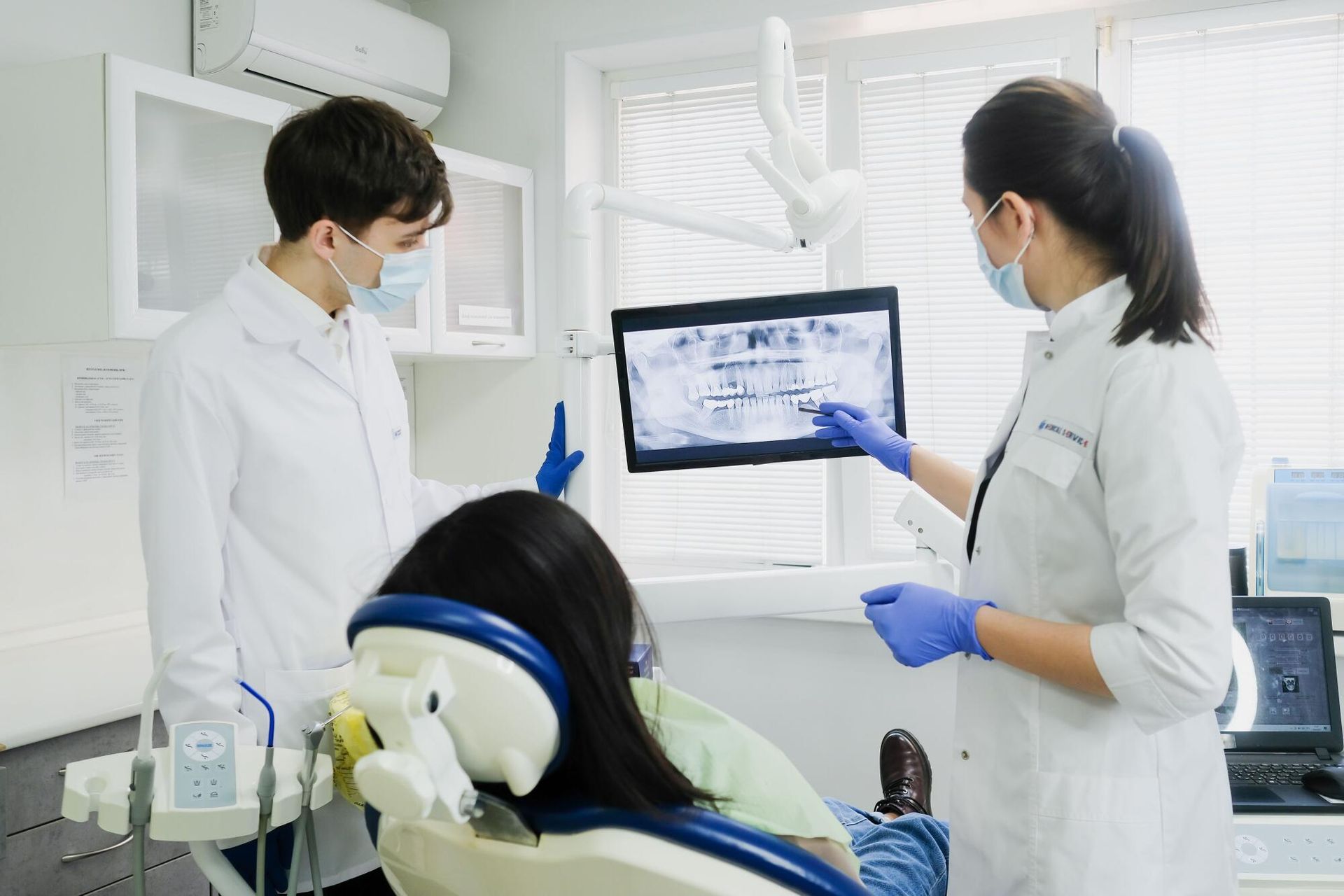 Dentist showing X-rays to a patient in a bright dental clinic