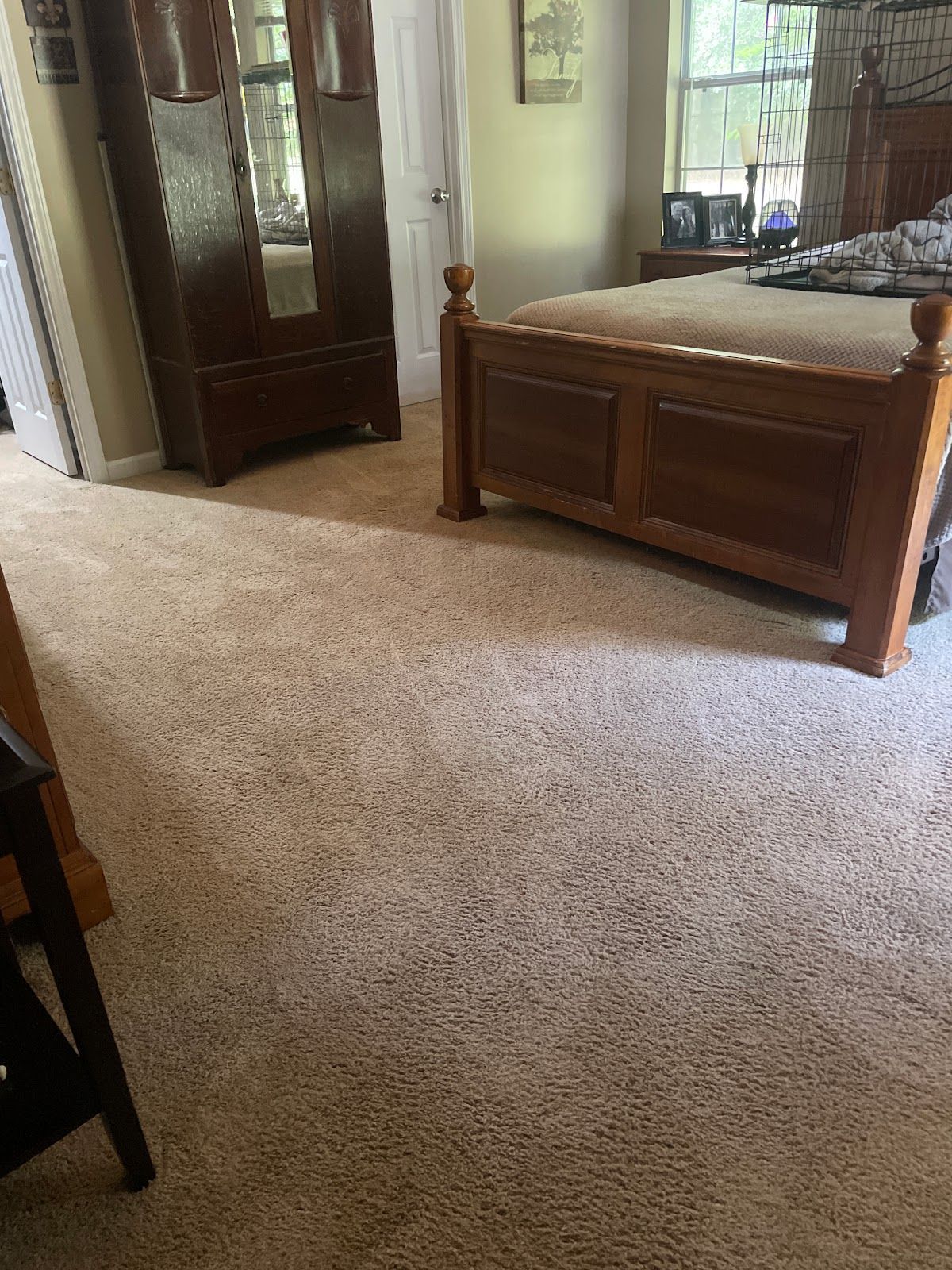 A bedroom with a bed , wardrobe , and carpet.