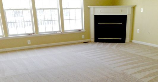 An empty living room with a fireplace and a lot of windows.