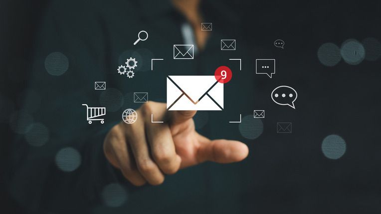 Een persoon wijst naar een e-mailicoon met een melding, omringd door andere digitale iconen.