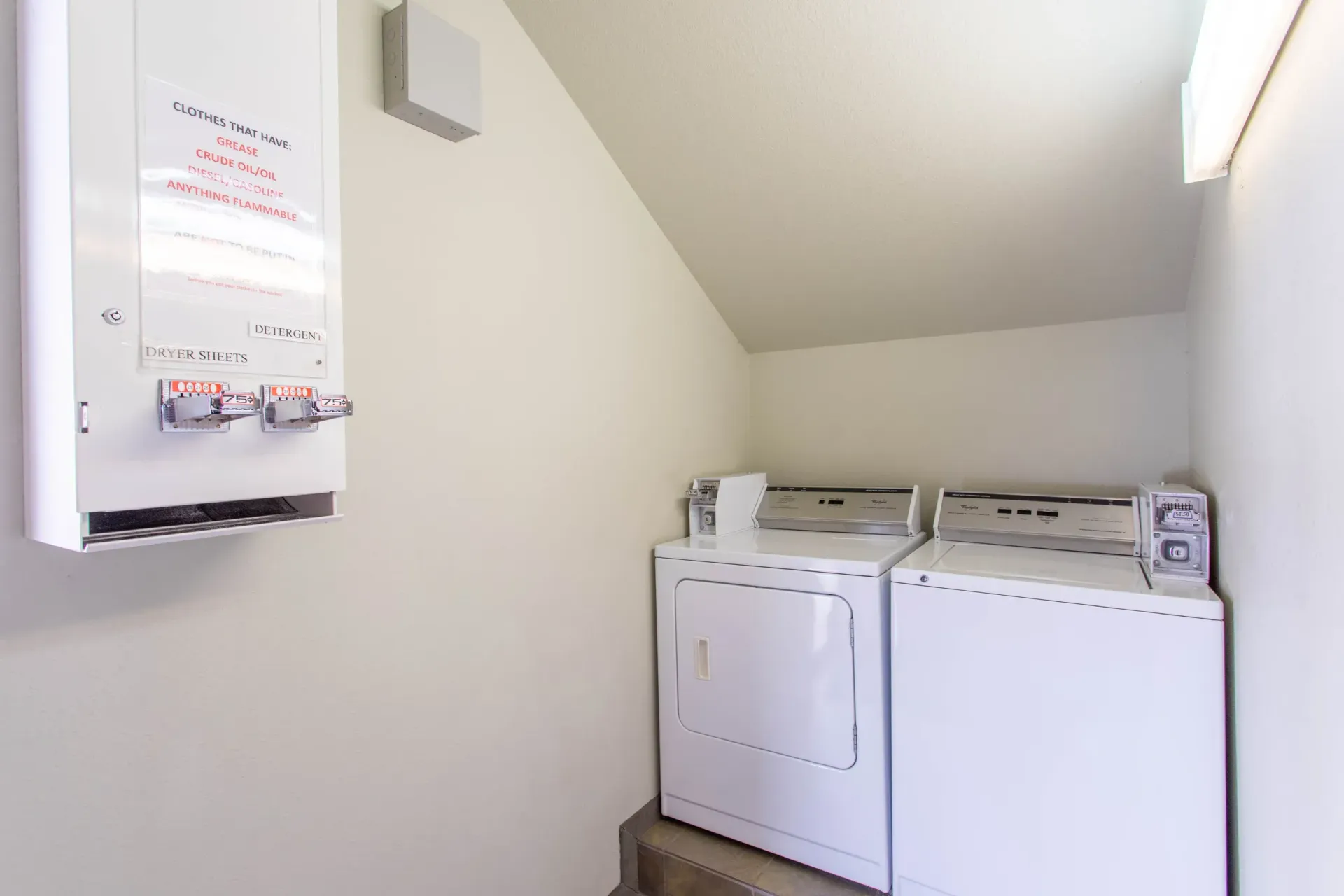 Laundry room with a washer and dryer, water heater, and a light fixture.