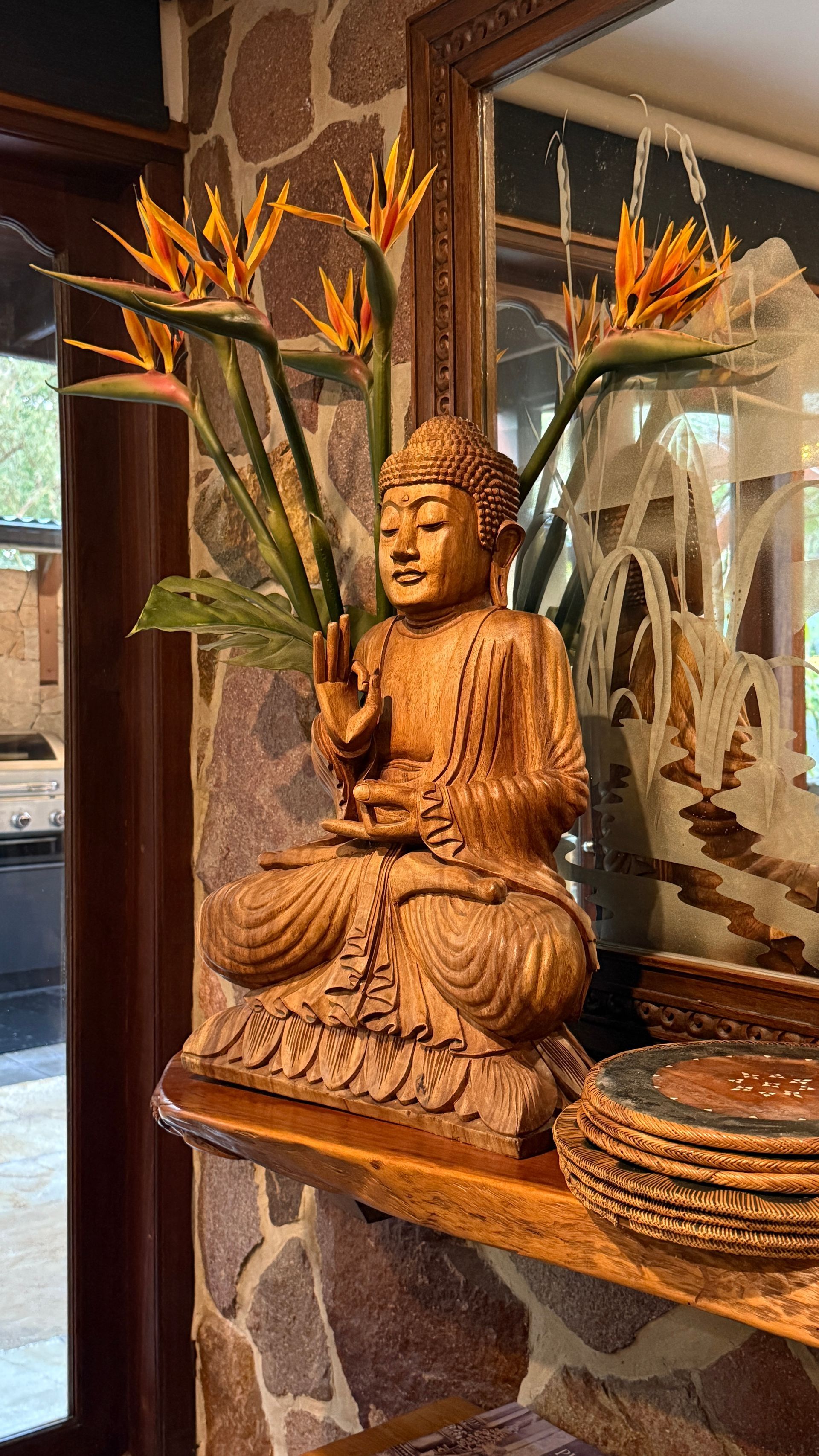Wooden Buddha statue with Bird of Paradise flowers — Bali at the Bay in Nelson Bay, NSW