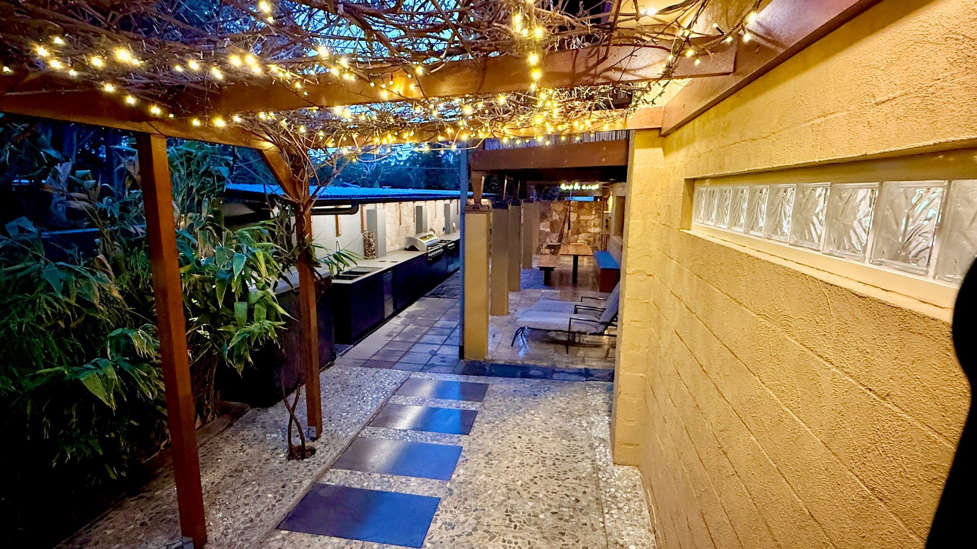 Pathway with string lights under a wooden trellis, leading to a garden area — Bali at the Bay in Nelson Bay, NSW