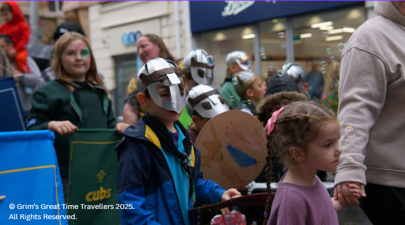 Children dressed as Vikings with helmets walk in Havelok parade