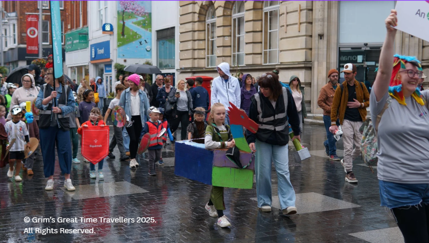 Children march in parade with model longship for Havelok Viking event