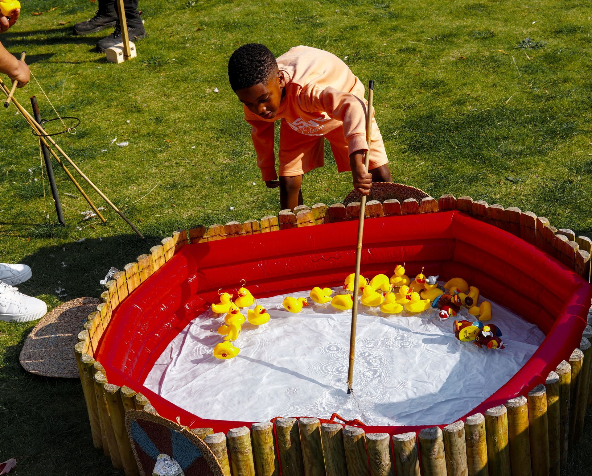 A boy is playing with rubber ducks in a pool